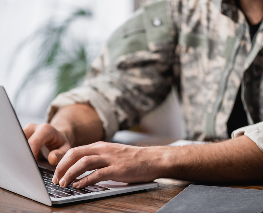 Cropped View Of Military Man Using Laptop On Desk