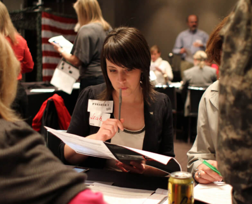 Front View Of Woman Looking At Paper While In Seminar